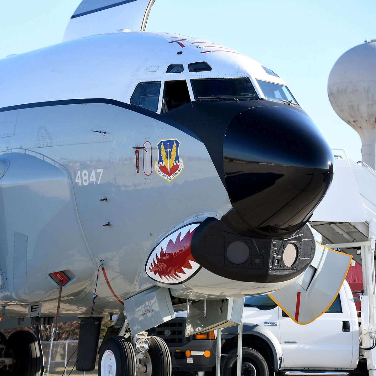 Close-up of RC-135U Combat Sent’s cockpit and black nose, showing chin antennas, shark-mouth artwork, number 4847 and Air Combat Command insignia.